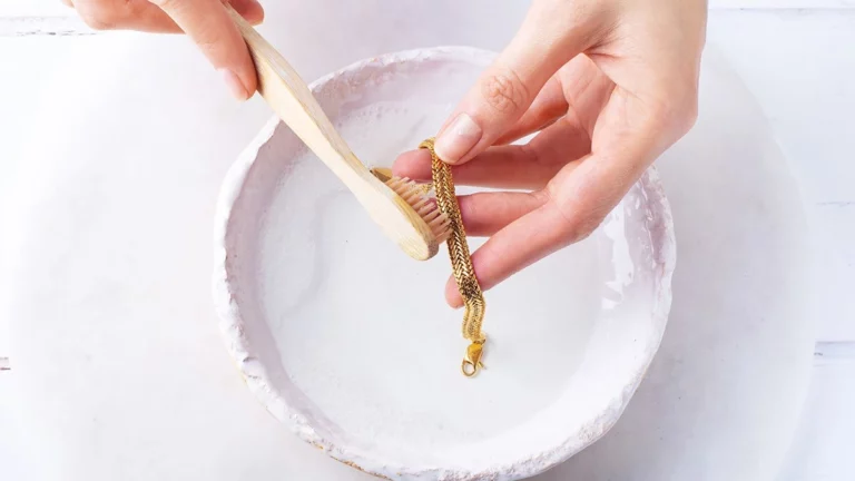 A girl cleaning her jewelry piece with a soft brush